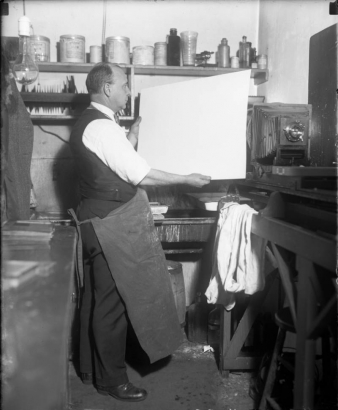 Interior view of Harry M. Rhoads in his dark room; also shows a bellows camera.