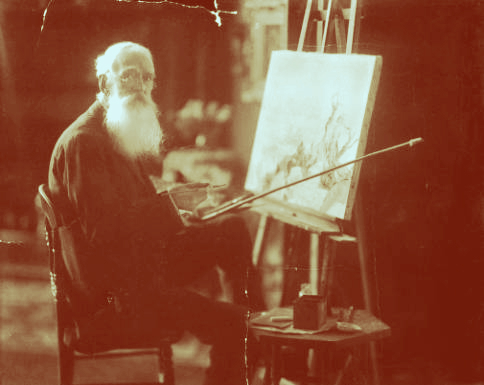 A man sits at an easel painting