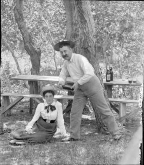 Woman seated on ground next to standing man