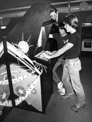A couple of young wizards put a coin-operated electronic machine through its paces at the Nautilus Video Arcade in the Southglenn Mall