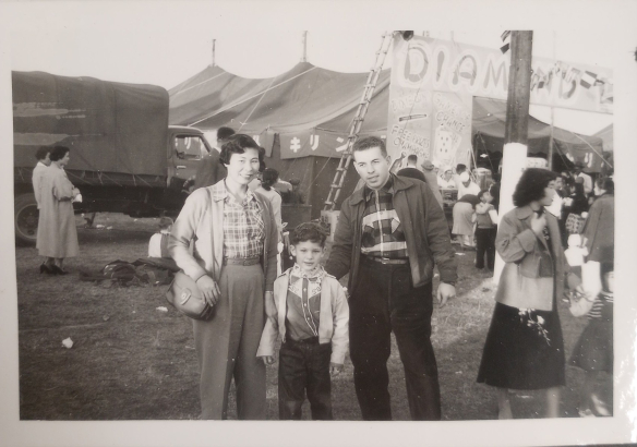 Kimiko (left) and Gene (right) posing with a child (center) at a fair, circa 1960s. 