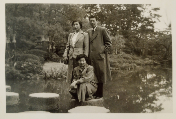 Kimiko Side (left) posing on a stepping stone with two friends in Japan, circa 1950s.