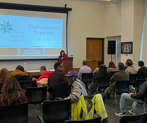 A picture of library officials speaking the community during the Blair-Caldwell Town Hall.