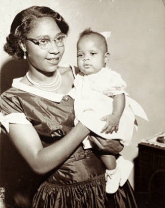 Mother poses with her infant daughter for a family portrait