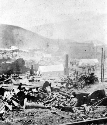 Rubble and debris caused by second fire of April 29, 1896, Cripple Creek, Colorado; twisted sheet metal, chimneystack, canvas tents amidst rubble.