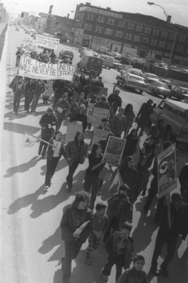 AFL-CIO United Farm Workers of America members and their supporters march in support of the grape and Gallo Wine boycott through Denver, Colorado. A large group of people carry banners and signs. A banner reads: "The People United Will Never Be Defeated." Signs read: "Boycott Grapes," "United Steel Workers for Rank and File United Boycott" and "Farm Workers Say No Lettuce, Grapes and Gallo."