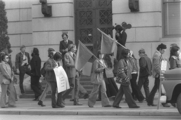 United Farm Workers of America (UFW) supporters picket the Denver City and County building in Denver, Colorado. The picketers protest Judge Robert Cummins' decision to jail UFW coordinator Jerry Ryan for refusing to remove his "Boycott Gallo" button at the beginning of his trial for a prior arrest for picketing. One picket carries a sign with a skull and crossbones that reads: "Cummins drinks Gallo Wine."