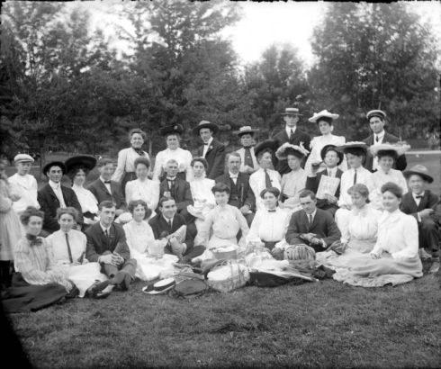 Group portrait of men and women with picnic baskets in Denver, Colorado.