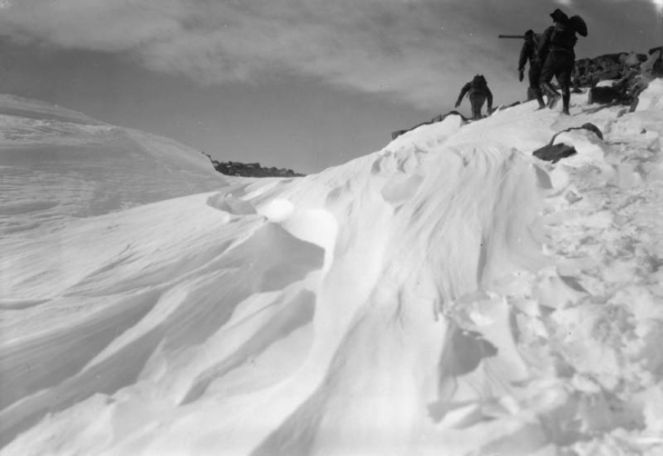Members of the AdAmAn Club climb among rocks and snow, above Colorado Springs, El Paso County, Colorado. Contoured banks and drifts of snow are in the foreground.