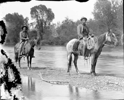 Men on horseback pose on a sandbar in the South Platte River in Denver, Colorado.