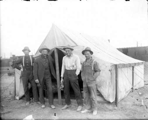 Outdoor portrait of a group of construction workers, they stand near a tent at the Alameda underpass construction site, Denver, Colorado.