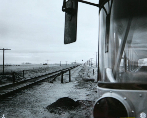 This photograph depicts the angle at which the road and the tracks intersected. The bus is parked in the area where Duane Harms stopped to look for a train before driving over the crossing.  The photo is from the trial exhibits of defense attorney Jim ...