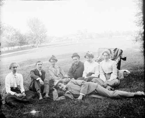 Outdoor portrait of a group of men and women in City Park, Denver, Colorado. The pavilion is in the distance.