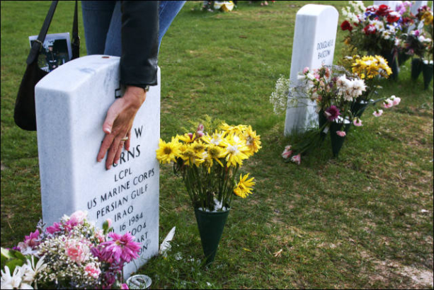 Lori DeMille touches the headstone of fallen Marine Lance Corporal Kyle Burns.