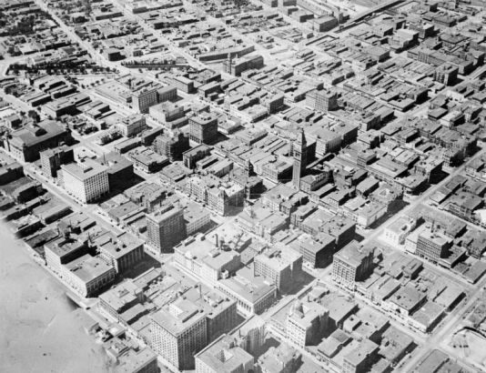 A photograph of a photo of an aerial view of downtown Denver. The Daniels and Fisher tower is in the middle of the photo.