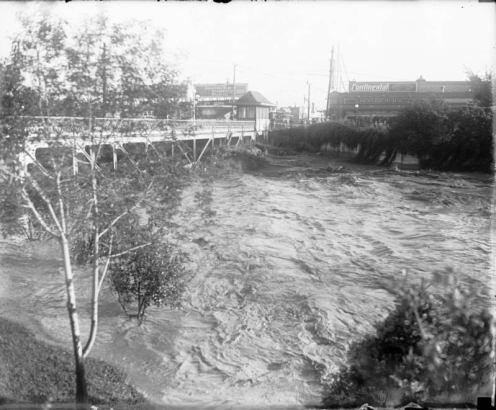 View of Cherry Creek and the 8th (Eighth) Avenue bridge in Denver, Colorado. Waves arise from flood water resulting from the breach of the Castlewood Canyon Dam.