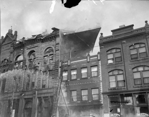 Shows a fire at the east Denver Turner Hall of the Turnverein Society located at 22nd and Arapahoe in Denver, Colorado. Damage from the fire was estimated at $150,000. The Denver Turner hall was built in 1889. Business sign reads "The Dearfield Cafe."