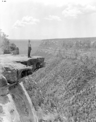 A man stands on a projecting rock overlooking the canyonlands in Mesa Verde National Park, Colorado.