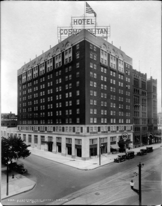 Cosmopolitan Hotel, 1760 Broadway, Denver, Colorado (William N. Bowman, architect); shows sign "Hotel Cosmopolitan," United States flag, automobiles, streetlights, and trolley tracks.