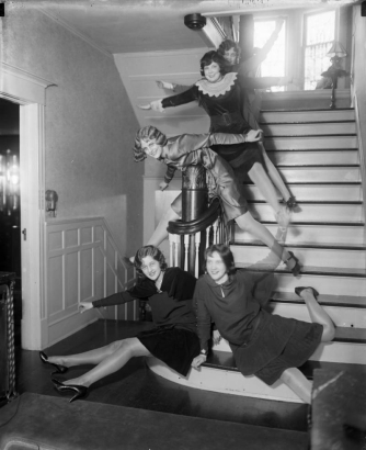 Interior view house shows women posing on a staircase in possibly Denver, Colorado.