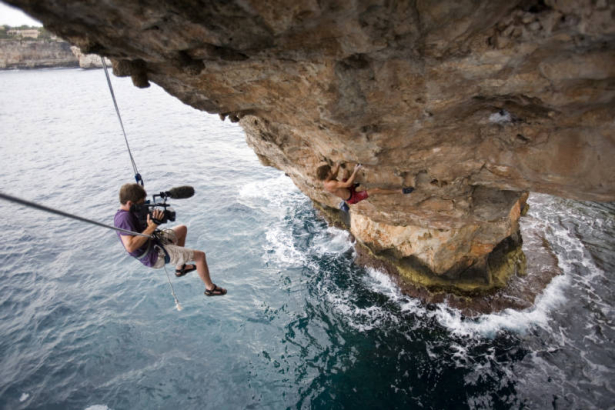 Josh Lowell filming Chris Sharma rock climbing / deep water soloing on The Arch, his project in Cala Santanyi, Mallorca, Spain. As of July 18, 2006 Sharma had not completed the free climbing route.