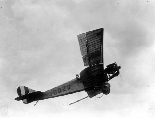 View of a Curtiss JN-4 training airplane in flight; letters read: "38029."