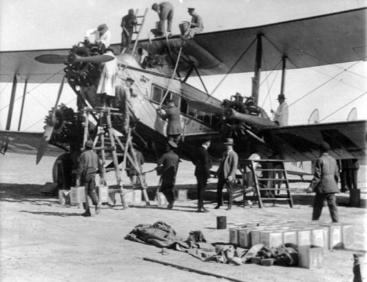 View of a De Havilland D. H. 66 Hercules G-EBMX ("City of Delhi") airplane being refueled. It has three 450 horsepower Bristol Jupiter engines, and is in the employ of Imperial Airways. Men climb on the wings and fuselage.