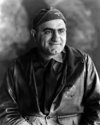 Portrait of Nolie Mumey, pilot, flight surgeon, author, historian, and poet, at Lowry Field in Denver, Colorado. He wears a leather flight jacket and garrison cap.