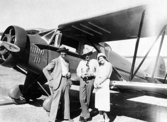 Walter Higley (pilot, businessman, and educator) poses by a Waco cabin airplane in Denver, Colorado, with Les Bowman and Edna McLaughlin.
