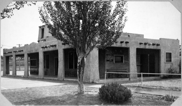 View of the Denver Municipal Trap Club clubhouse at Sloans Lake Park in Denver, Colorado. The adobe style building has wooden vigas and a sign that reads: "Denver Municipal Traps".