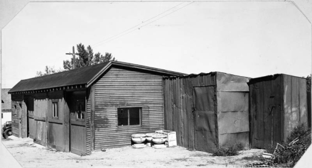 View of the garages and tool shed at the Willis Case Municipal Golf Course (formerly Rocky Mountain Golf Course) in Denver, Colorado. Round and rectangular planters are near the buildings.