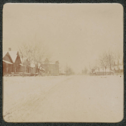 View of a residential street in Denver, Colorado. Snow covers the ground and houses.