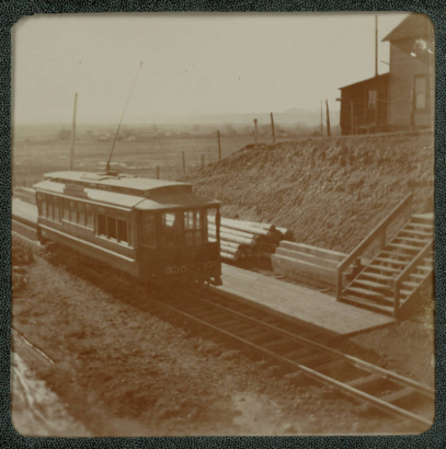 View of the Denver City Tramway Company trolley #335 at the Arvada Depot in Arvada, Colorado. Stairs lead to from the tracks to the station.