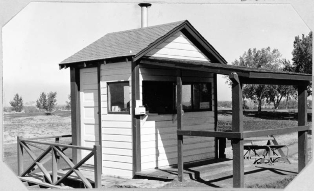 View of the starter's building on the first tee at the Wellshire Golf Course (Wellshire Country Club) in Denver, Colorado. A wooden bench is nearby.