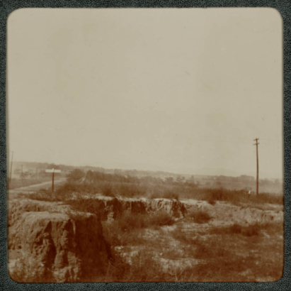 View of a canyon and dirt road possibly near Denver, Colorado. Powerlines and poles cross the canyon.