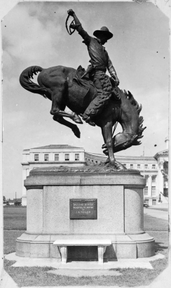 View of a statue of a cowboy on a bucking bronco in Civic Center Park in Denver, Colorado. The statue was sculpted by Denver artist Alexander Phimister Proctor. A plaque on the statue reads: "'Broncho Buster' presented to Denver by J.K. Mullen A.D. 1920."