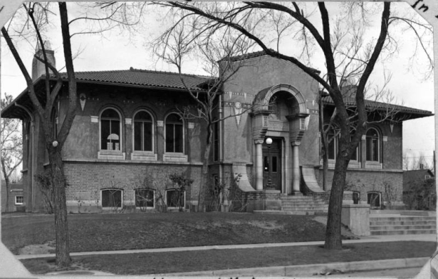 A view of the Henry White Warren Branch Library located at 34th and High Street in Denver, Colorado. The Warren branch was designed by the Fisher Brother's architects and features an Italian style design with a red tiled roof, brick foundation and cement walls. This branch opened in 1913.