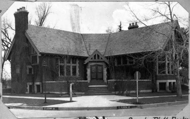 A view of the Sarah Platt Decker Library Branch located in James H. Platt Park on Iowa and Logan streets in Denver, Colorado. The Decker library branch was constructed in 1913. The V-shaped English cottage features tiled roof, raised courtyard, gabled entry, chimneys and concrete trim. The branch was named for Sarah S. Platt Decker, a suffragette, club woman, and civic benefactor.