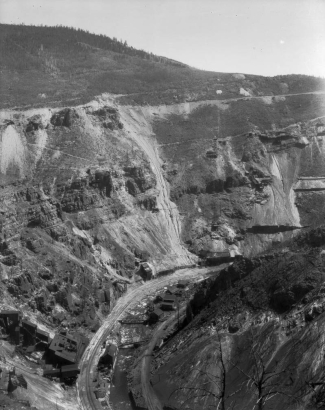 Belden mine complex and Denver and Rio Grande Western Railroad tracks flank the Eagle River, at Gilman (Eagle County), Colorado; mining buildings dot surrounding cliffs.