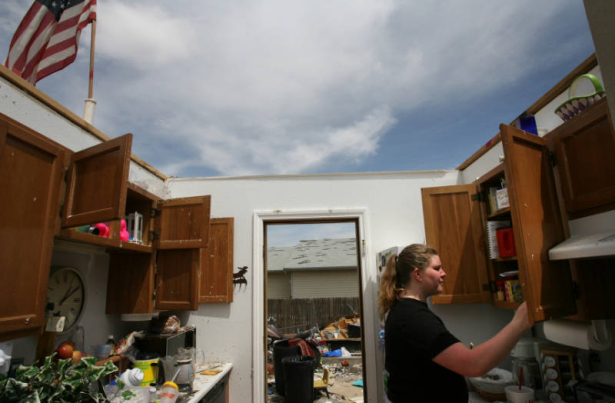 ({seqn)} Allison Larson looks in her kitchen cabinet while meeting with insurance agents at her home on Sunday, May 25, 2008. The Larsons' house was destroyed in the tournado that hit Windsor, Colo., last week.  (PRESTON GANNAWAY/ROCKY MOUNTAIN NEWS)  ...
