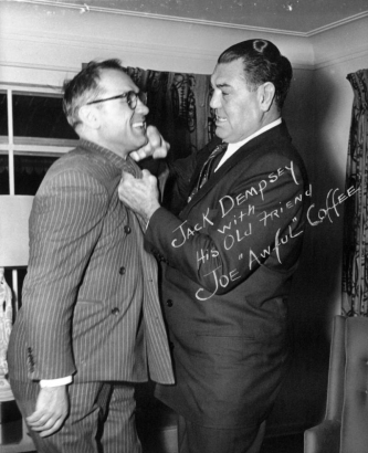 Jack Dempsey poses with Joe "Awful" Coffee probably in Colorado. Both men wear suits.