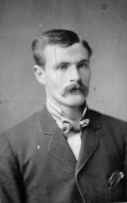 Studio portrait of William Henry Jackson in Denver, Colorado. He wears a suit and bow tie.