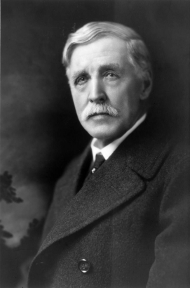Studio portrait of William Henry Jackson. He wears an overcoat and tie.