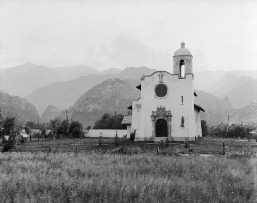 The Pauline Chapel at the Hotel Broadmoor, El Paso County, Colorado, is a mission-style building with cupola, tile roof, ornate-carved stone door frame, and niche-sculpture of Saint Paul.