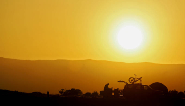 Mountain bikers with bikes in tow camp near the Bookcliffs area as the sun sets after riding at the 11th Annual Fruita Fat Tire Festival on Friday April 28, 2006. The Festival went back to its roots this year featuring loosely organized rides many host...
