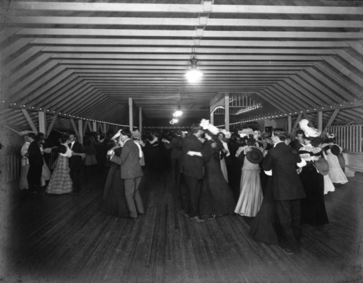 Interior view of a dance hall at Manhattan Beach amusement park in Denver, Colorado; shows men and women dancing.