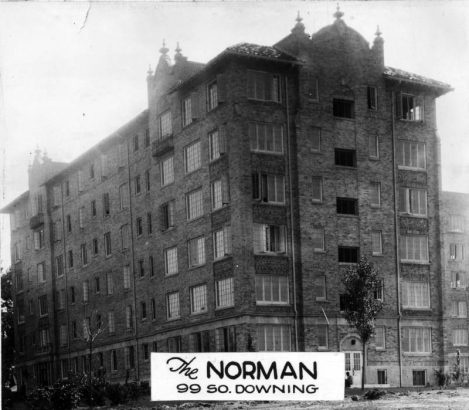 View of The Norman apartments at 99 South Downing Street, in Denver, Colorado; features of the six-story building include brick mission style pediments and finials.