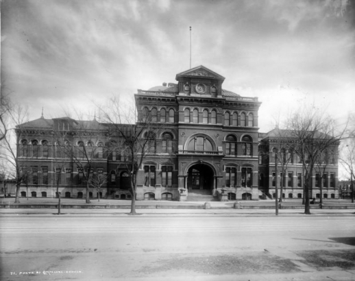 Exterior view of old East Denver High School, (1889-1925) 19th (Nineteenth) and Stout, Colorado, shows a brick building with stone trim; three-story middle section with massive dome and center bay, two-story wings and stone foundation.
