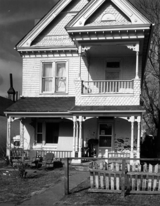View of 2825 Curtis Street in the Curtis Park neighborhood (Five Points) in Denver, Colorado; shows a frame house with shingle imbrication and a covered porch and balcony.