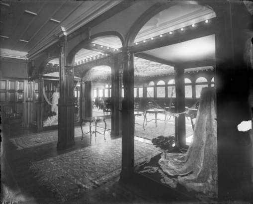 Interior view of the Daniels and Fisher store in Denver, Colorado; shows a room with stained glass windows, coffered ceilings, lace, tables, chairs, and Oriental rugs.